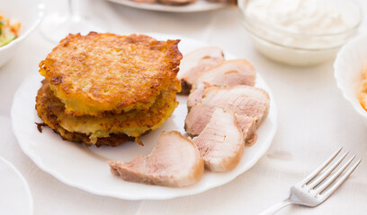 Potato pancakes with meat on white plate