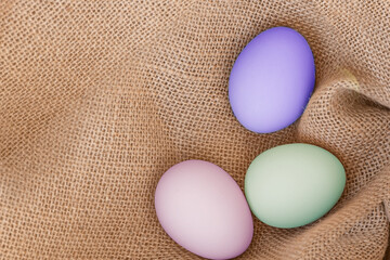 Easter eggs on a sackcloth . Happy Easter multi colored easter eggs. Background with easter eggs. Flat lay, top view.