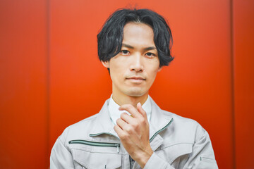 作業服を着てエレベーターの前に立つ若いビジネスマン