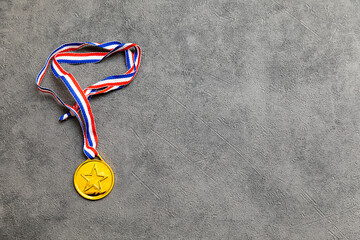 Simply flat lay design winner or champion gold trophy medal on concrete stone grey background....