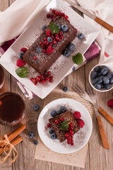 Chocolate sponge cake with fresh fruit on white dish.