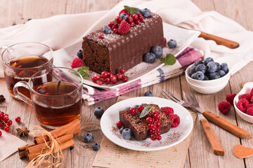 Chocolate sponge cake with fresh fruit on white dish.