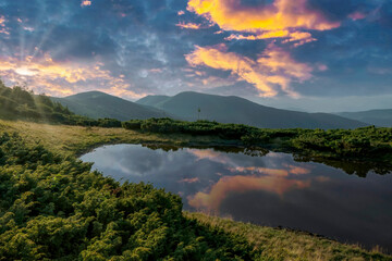 Fototapeta na wymiar Colorful sunset sky reflecting in the small mountain lake