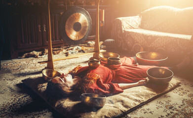 beautiful woman playng on tibetan bowl. Woman on music therapy. ceremonial space.