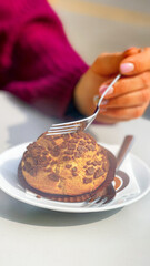 Woman eaiting tasty chocolate cake on the table.