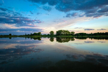 Reflection of evening clouds in the water of a calm lake, Stankow, Poland