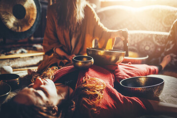 beautiful woman playng on tibetan bowl. Woman on music therapy. ceremonial space.