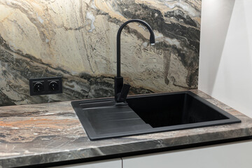 Black sink in the kitchen in a modern interior