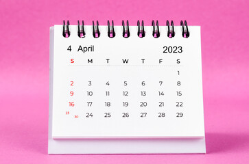 Obraz na płótnie Canvas The April 2023 desk calendar on pink color background.