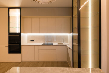 Modern kitchen in the interior of a new apartment in beige tones