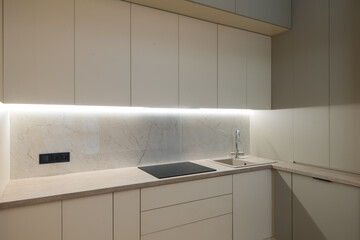 Modern kitchen in the interior of a new apartment in beige tones