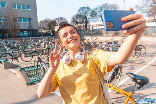 Woman takes a selfie with cellphone in a bicycle parking