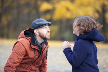 a father spends time with his teenage daughter in an autumn park