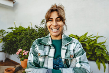 Happy Latin woman gardening at home