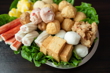 Various steamboat ready to cook ingredient that include fish ball, tofu, squid ball, fish cakes and vegetables.