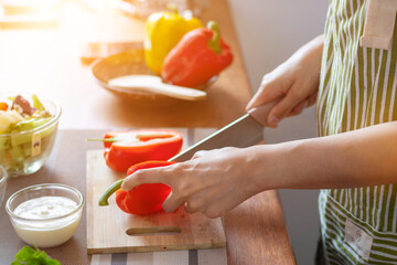 A young woman prepares bell peppers for her breakfast and is ready for a healthy meal on the table with healthy, organic vegetables on the table. healthy food preparation ideas