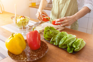 A young woman prepares bell peppers for her breakfast and is ready for a healthy meal on the table with healthy, organic vegetables on the table. healthy food preparation ideas