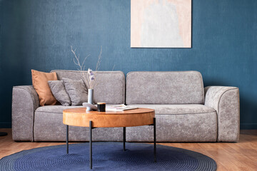 Modern living room with sofa and furniture. Dark blue wall