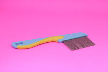 comb for fleas isolated on pink background