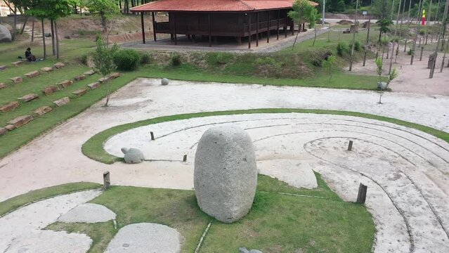 shows the camera moving to the right, rotating around a boulder, an ancient site on Bumi Ragem Sai Mangi Wawai, Lampung Indonesia.
