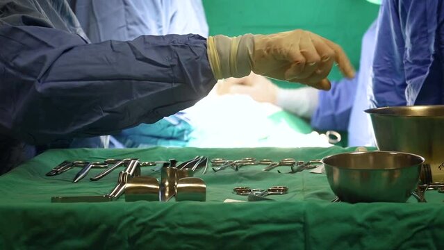 Surgical scissors on tray with surgeons performing surgery in the flu background.
