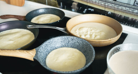 Russia Moscow 14.03.2021 Cooking many big tasty pancakes Lot of pans,oil,pancake dough.Russian traditional national festival winter Maslenitsa holiday week,shrovetide. Man, father cook.Family holiday