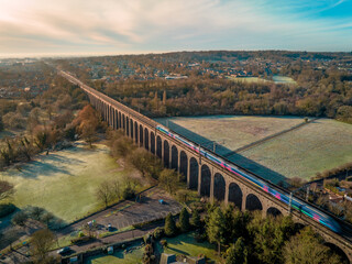 UK Commuter Train Travelling Across a Viaduct at Sunset