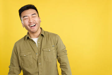 Obraz premium Chinese man laughing with eyes closed while standing