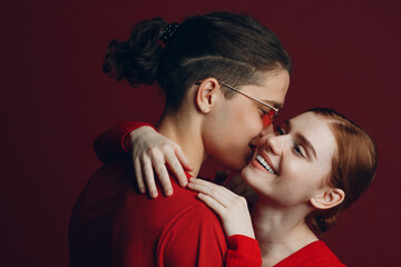 Beautiful young couple hugging on red background. Valentine's day