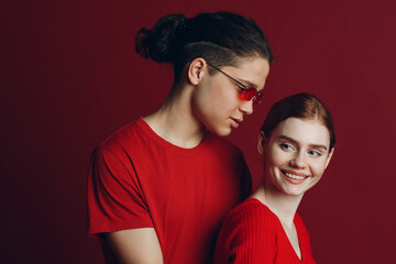 Beautiful young couple hugging on red background. Valentine's day