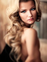 Fototapeta premium Blonde female with intricant blue eyes and fashionable hair in a portrait in warm lighting