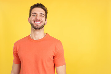 Handsome man standing with arms crossed laughing at the camera