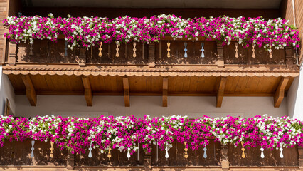 Traditional flowered balcony at the Alps and Dolomites. Colorful flowers on balcony. Summer time. Mix of flowers and colors. General contest of the European Alps