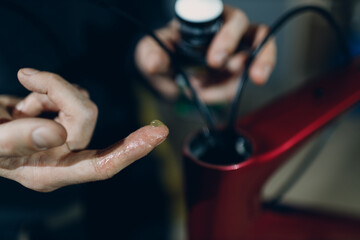Mechanic repairman assembling custom bicycle lubricant oiling in workshop