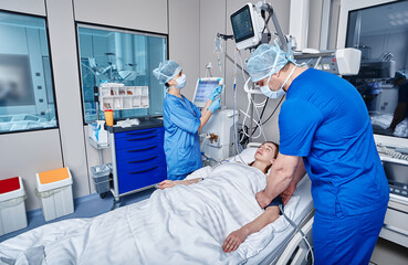 Fototapeta premium Staff nurses attending to patient in adult intensive care unit. ICU