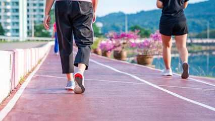 sport, exercise concept. runner woman wearing sports shoes for running, jogging on running track in stadium morning. people exercise of healthy and lifestyle. exercise outdoor in nature park in summer
