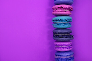 Colorful macaroons on violet background. Top view, flat lay style.