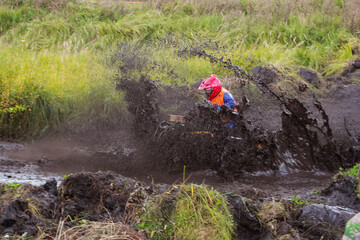 athlete on a quad bike rides in the mud