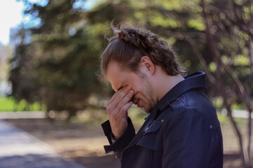 young man rubbing his eyes with his fingers