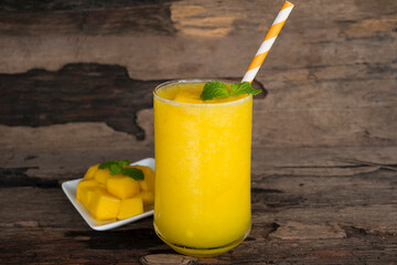 Mango juice fruit smoothies yogurt drink yellow healthy delicious taste in a glass slush for weight loss on wooden background.