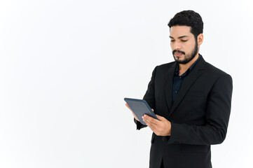portrait of cheerful attractive young businessman standing and using digital tablet isolated over white background.