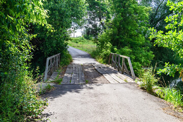 Fototapeta premium Beautifully standing old wooden bridge over river in colored background close up