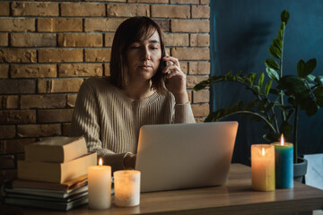 Young woman using laptop to work at home during electricity outage. Remote work at home concept....