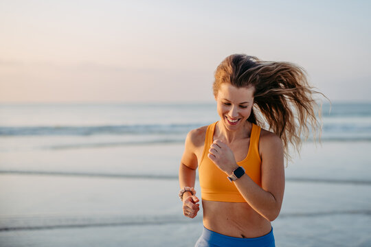 Young woman running at beach, morning routine and healthy lifestyle concept.
