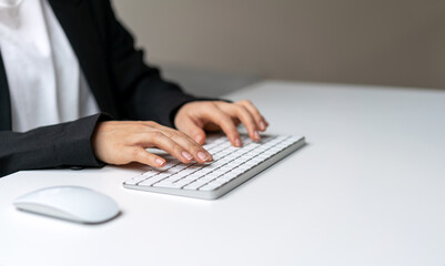Female hands on white computer's keyboard close-up photography with copy space. Template typing on keyboard.