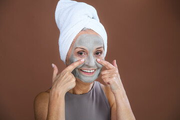 Portrait of happy senior woman with face-mask, selfcare and skin routine concept.