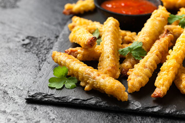 Fried Vegan jackfruit and oyster prawns in crispy batter served on black slate with chili dip sauce