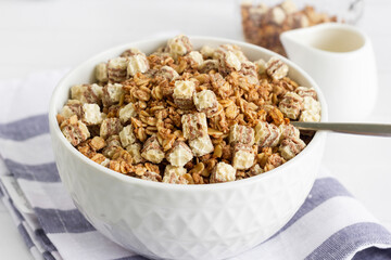 Breakfast cereal served in a white bowl with a glass of milk on a kitchen table