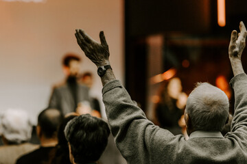 Elder man rise his hand while he is praise God at church service - 570922752