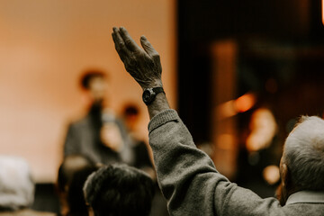 Elder man rise his hand while he is praise God at church service - obrazy, fototapety, plakaty